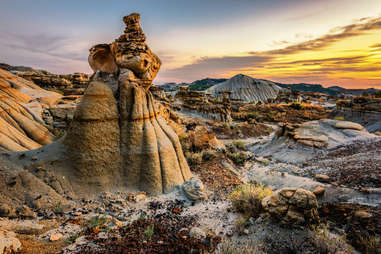 a large desert with brush and strange hoodoo rock formations