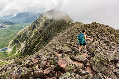 person hiking along a craggy mountaintop