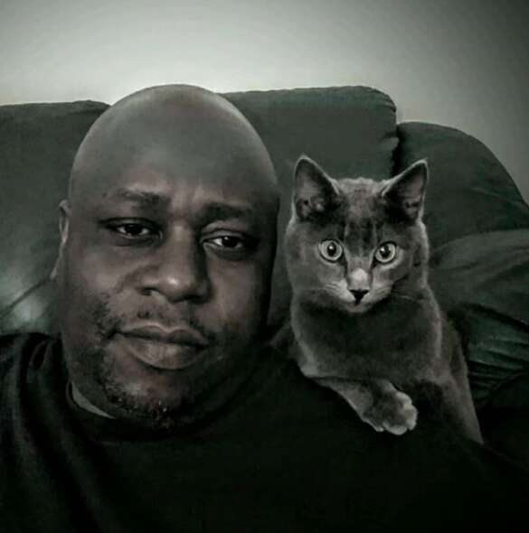 Animal rescuer Calvin Tucker poses with his cat Henry