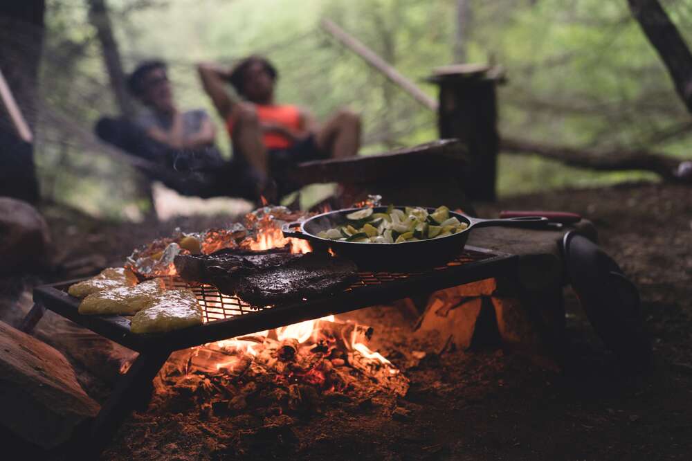 Man Holding Tea Kettle Over Campfire With Stick High-Res Stock Photo -  Getty Images