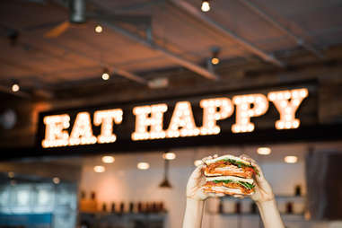 Mendocino Farms sandwich in front of "Eat Happy" sign