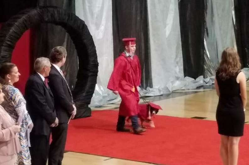 Kid graduates with service dog