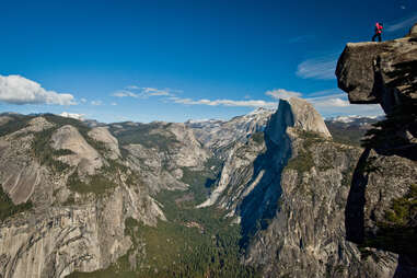 a person standing on a cliff above an enormous valley