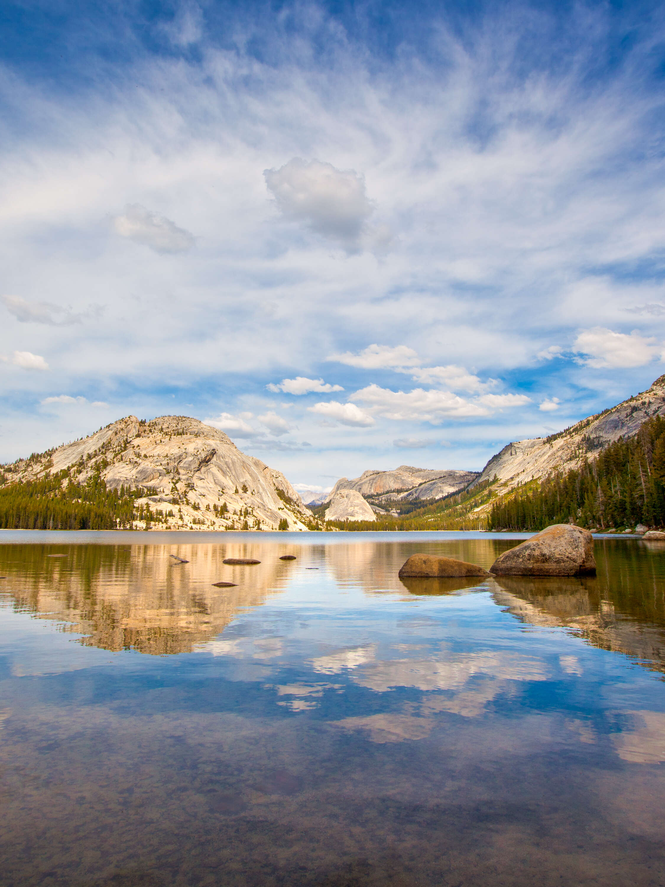 a lake reflecting mountains and the sky