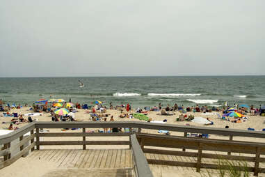 people with beach umbrellas gathered on a seashore