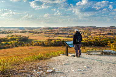 a person standing in front of a sweeping prairie vista