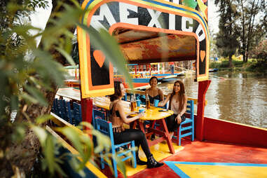 people on a boat sailing down a river in mexico