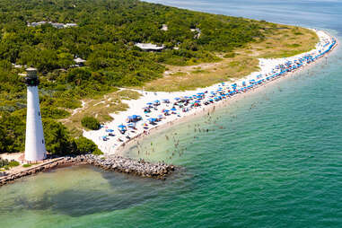 birds eye view of a lighthouse along a busy beach