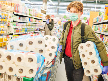 man stocking up on toilet paper in a store