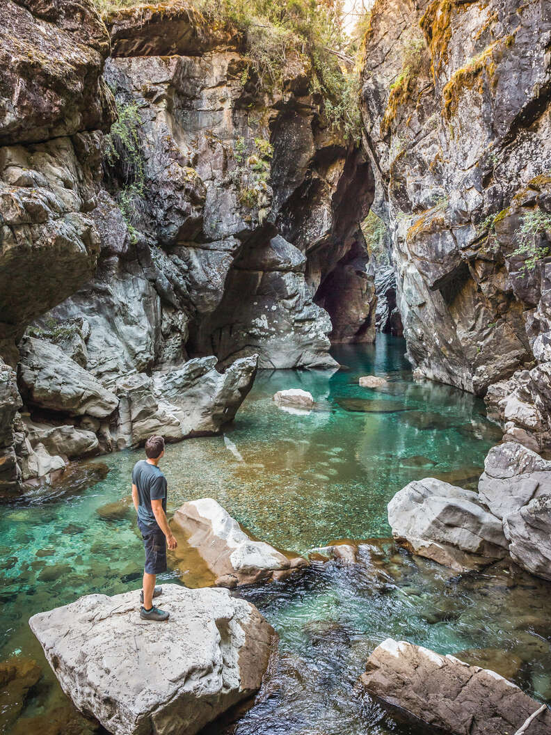 man standing in river azul gorge, cajon del azul