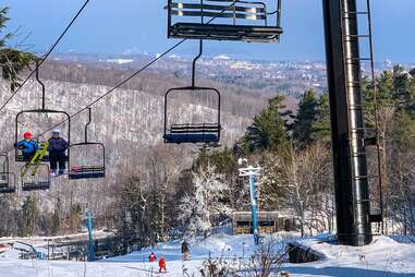 people on a ski lift headed down a mountain
