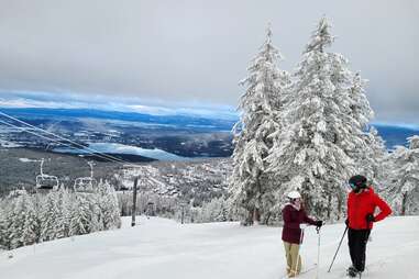 skiers standing at the top of a slope