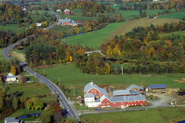 a road stretching past farms and fall trees