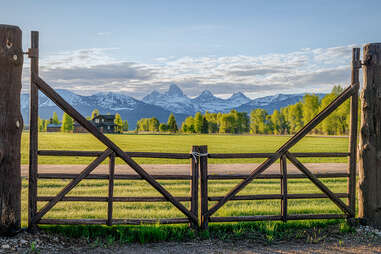 looking past a gate onto a field and mountains