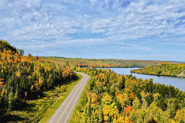 road leading through forest and past a lake