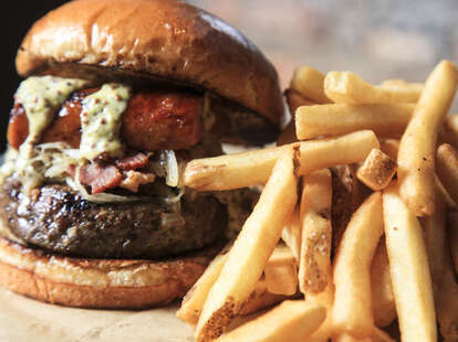 A massive burger with a Polish sausage in between the buns.