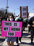 People hold signs as they march during a rally to support Stop Asian Hate at the Logan Square Monument in Chicago