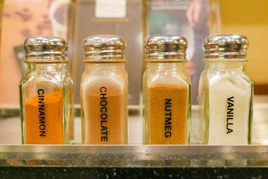 Starbucks condiment counter powder shakers: cinnamon, chocolate, nutmeg, vanilla