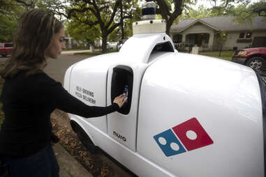Customer retrieves Domino's pizza order from Nuro R2 delivery robot