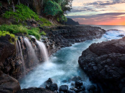 Waterfall near Queen's Bath at sunset, Kauai, Hawaii