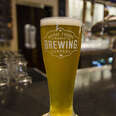 A pint of Whole Foods Brewing Co. beer on a bar.