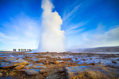 Strokkur, a famous geyser in Iceland, spouting against a blue sky