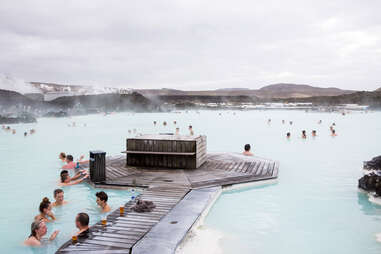 people sitting in milky blue water at the Blue Lagoon