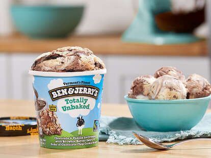 A pint of Ben & Jerry's Totally Unbaked beside a bowl of ice cream and a spoon.