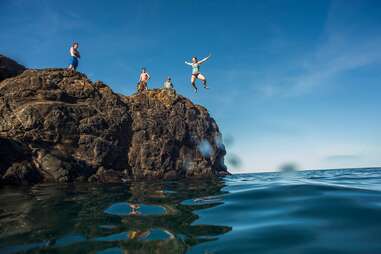 friends cliff diving into lake superior