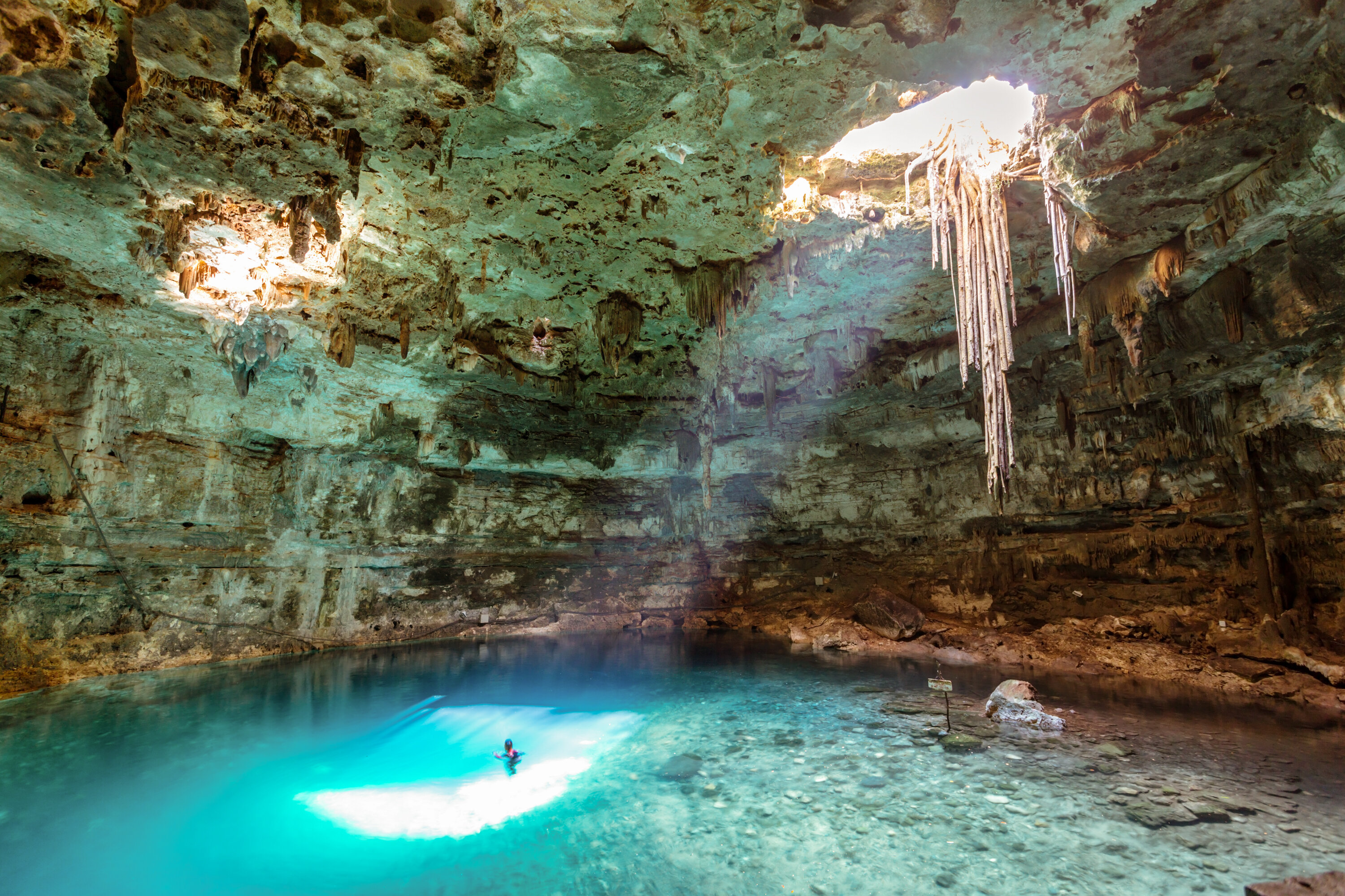 man swimming in cenote