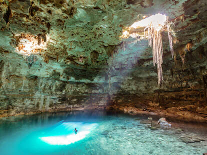 man swimming in cenote