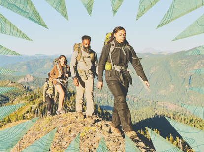 four people hiking over a mountain