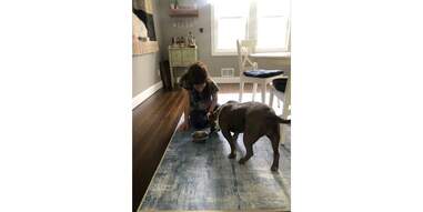woman feeding dog on a Ruggable rug on floor