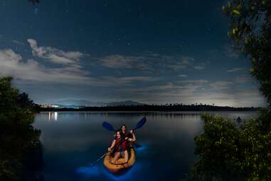 two women bio bay kayaking with shimmering water