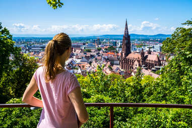 woman overlooking muenster cathedral in freiburg, germany