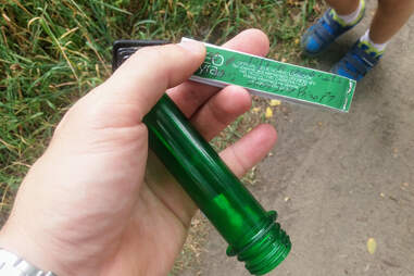 person holding a small tube-like geocache