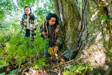 a couple geocaching in the woods