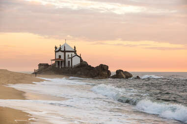 Capela do Senhor da Pedra chapel at sunset on Praia de Miramar, Portugal