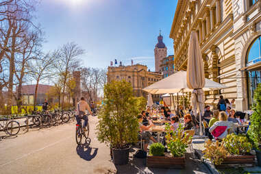 person riding bike past cafe in leipzig, germany