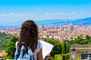brunette Woman traveler with Map over Cathedral of Santa Maria del Fiore (Duomo) in Florence, Italy