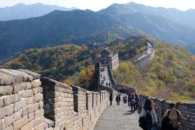 people walking along a mountainous section of the Great Wall of China