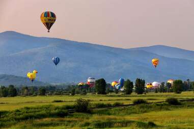 hot air balloons taking flight in the mountains