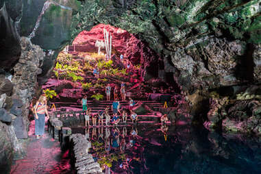people crowded near an underground cavernous lake
