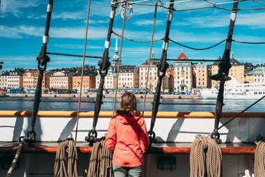 woman looking out from a ship on a european old town