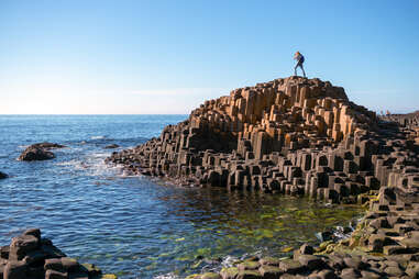 A woman explores the unique hexagonal coastline at the Giant's Causeway in Northern Ireland, one of the region's top tourist attractions