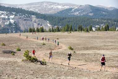 athletes running along a mountain trail