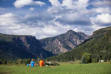 bikers sitting on a hill overlooking mountains