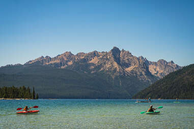 people canoeing on a mountain lake