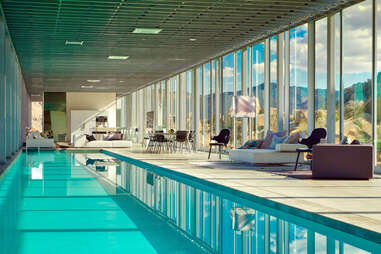 a giant indoor pool with couches overlooking a desert