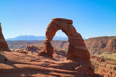 a giant stone arch formation with mountains in the distance